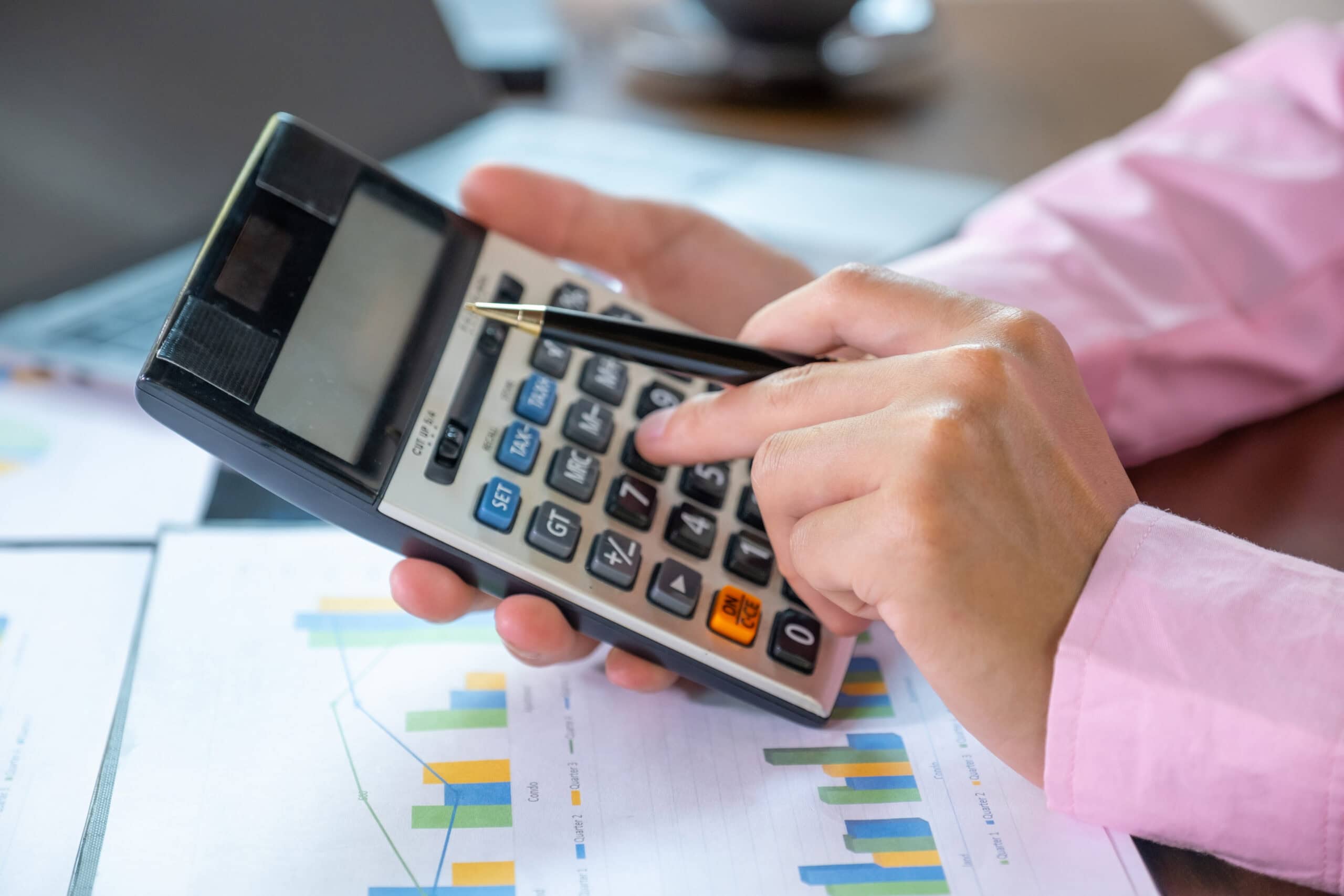 Businessmen bookkeeper hand use calculator and laptop doing account for paying tax on desk in working office.